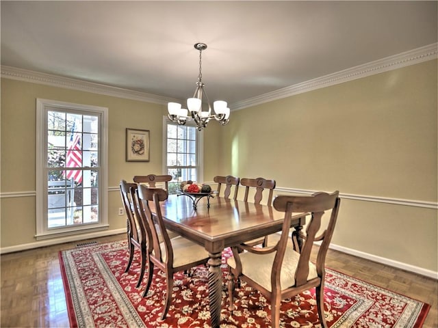 dining area with an inviting chandelier, crown molding, and dark parquet floors