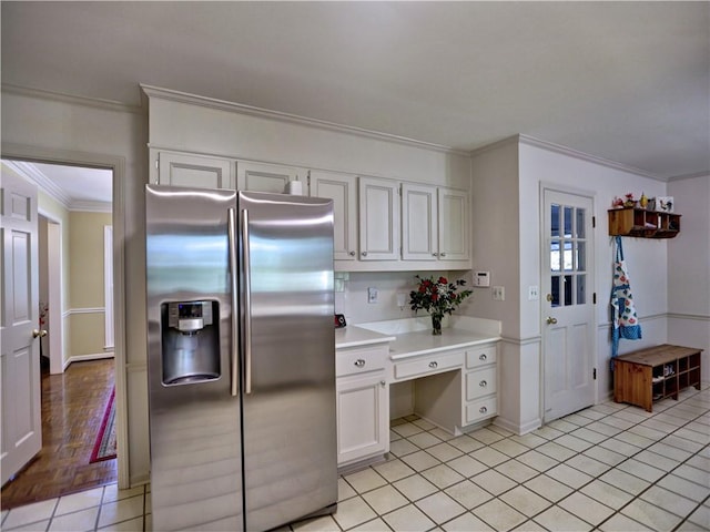 kitchen featuring white cabinetry, light parquet flooring, stainless steel fridge, and crown molding