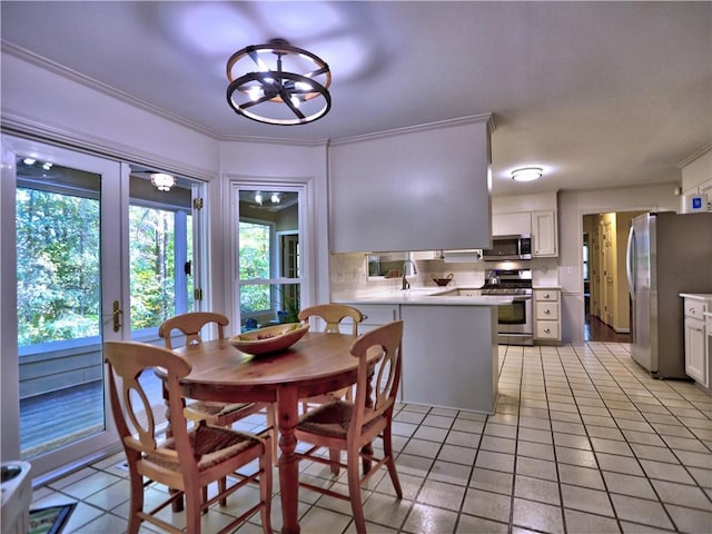 dining room with sink, light tile patterned floors, and ornamental molding