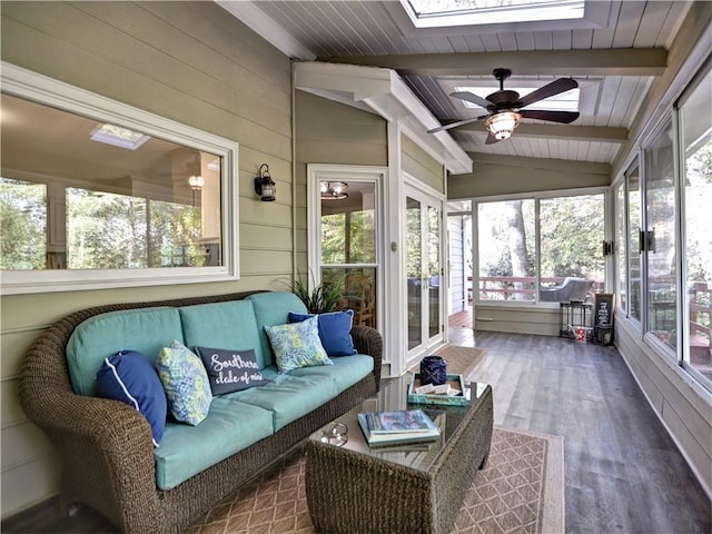 sunroom / solarium with ceiling fan, a wealth of natural light, and vaulted ceiling with skylight