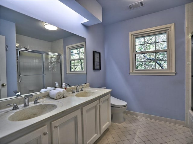 bathroom with vanity, toilet, tile patterned floors, and a shower with shower door