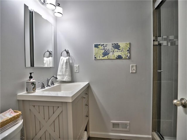 bathroom featuring vanity, toilet, and a shower with shower door