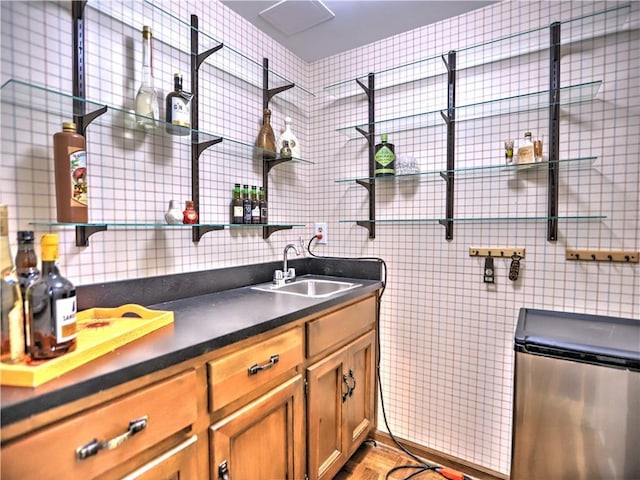 kitchen featuring sink, tile walls, stainless steel fridge, and light hardwood / wood-style floors