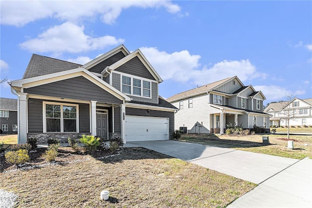 craftsman house featuring an attached garage, covered porch, driveway, and a residential view