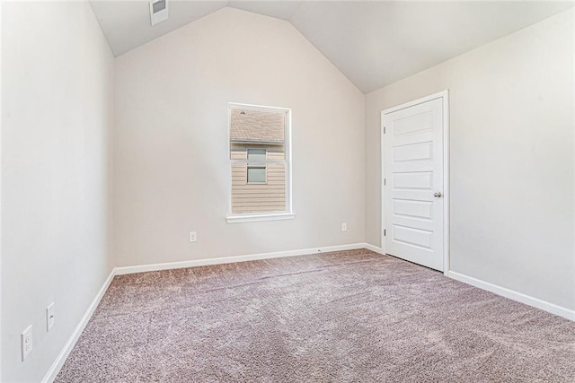 carpeted empty room with lofted ceiling, baseboards, and visible vents