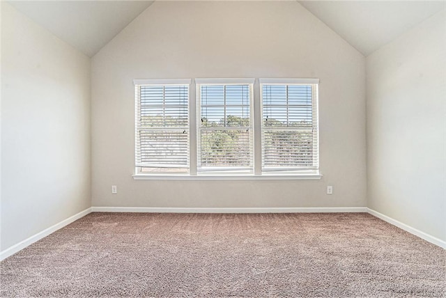 spare room featuring lofted ceiling, baseboards, and carpet floors