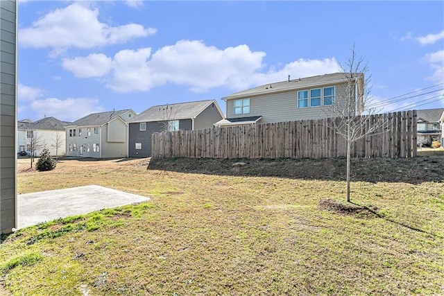 view of yard featuring a patio, a residential view, and fence