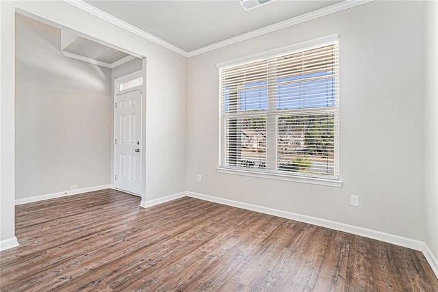 empty room featuring baseboards, ornamental molding, and wood finished floors