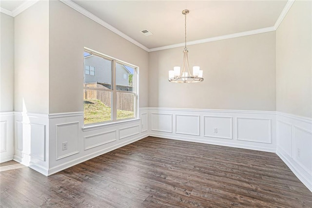 unfurnished dining area with a wainscoted wall, dark wood-style flooring, ornamental molding, and a notable chandelier