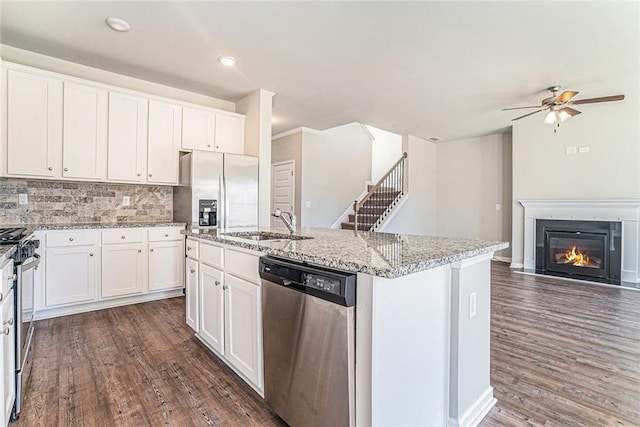 kitchen with dark wood-style flooring, stainless steel appliances, white cabinets, and light stone countertops