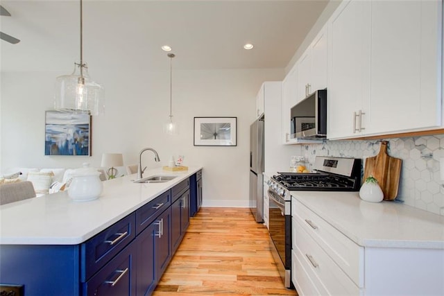 1240 Oakland Ter SW Unit B, Atlanta, GA 30310 - kitchen with a sink, a peninsula, light wood-style flooring, stainless steel appliances, and blue cabinetry