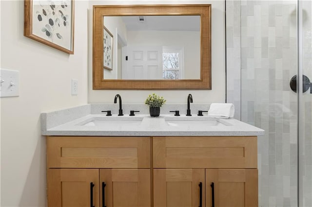 bathroom featuring a shower with door and vanity