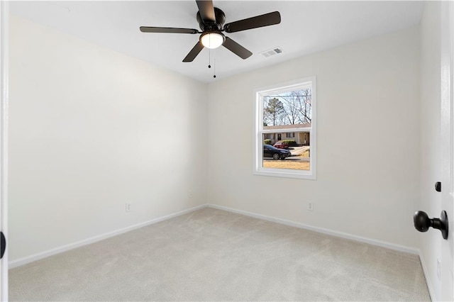 spare room featuring light colored carpet and ceiling fan