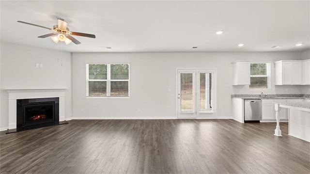 unfurnished living room with ceiling fan, dark wood-type flooring, and sink