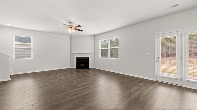 unfurnished living room with ceiling fan and dark wood-type flooring