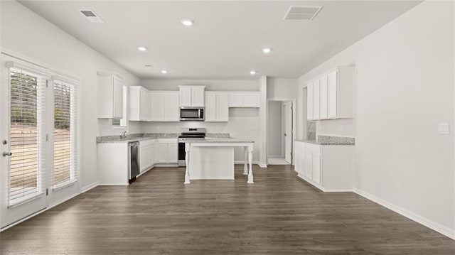 kitchen with white cabinetry, a kitchen island, a healthy amount of sunlight, and appliances with stainless steel finishes