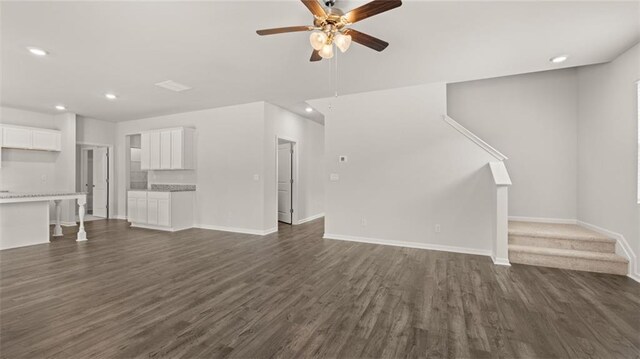 unfurnished living room with dark hardwood / wood-style floors and ceiling fan