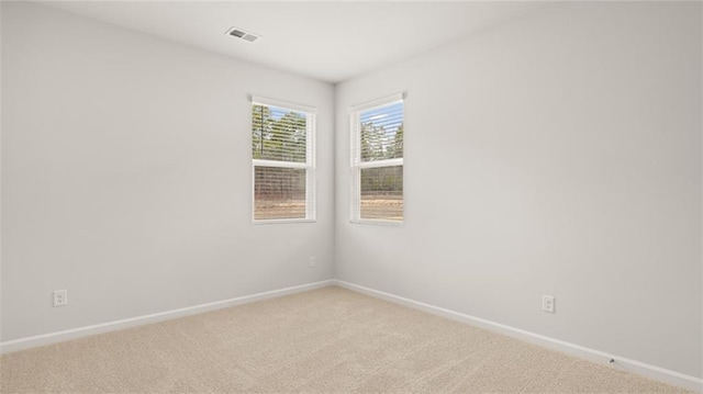 unfurnished room featuring light colored carpet