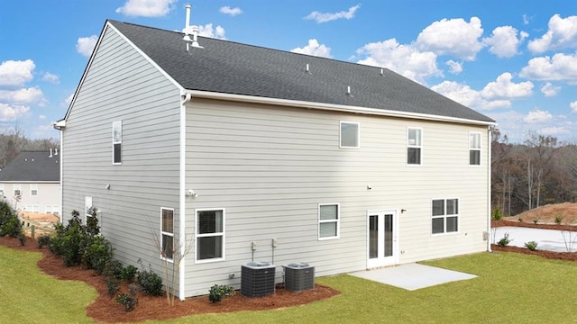 rear view of house with cooling unit, a yard, a patio, and french doors