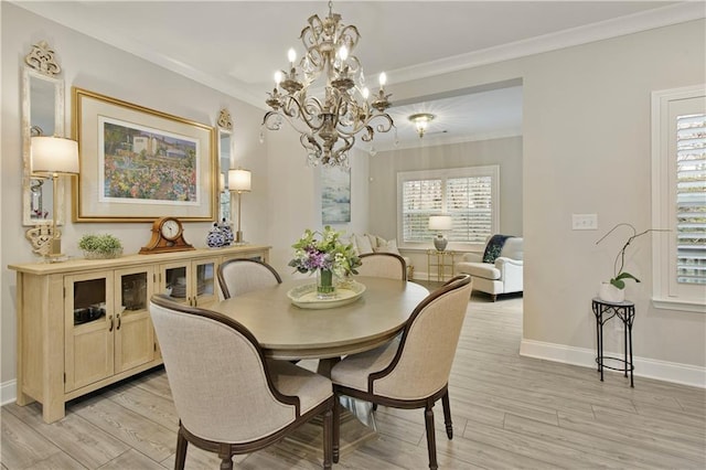 dining room with light wood finished floors, baseboards, and crown molding