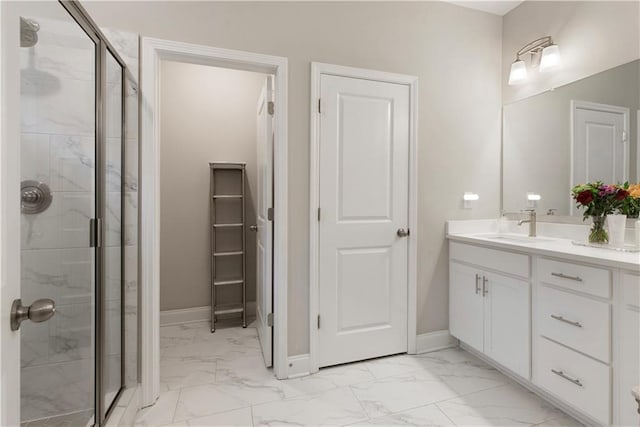 full bathroom with marble finish floor, baseboards, a shower stall, and vanity