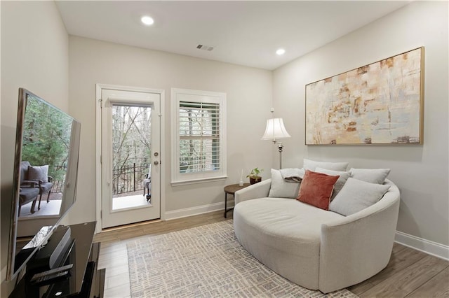 living area featuring recessed lighting, wood finished floors, visible vents, and baseboards