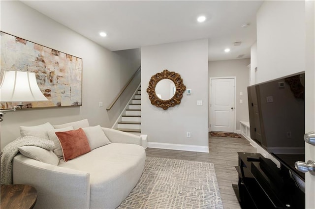 living room with light wood-type flooring, stairs, baseboards, and recessed lighting