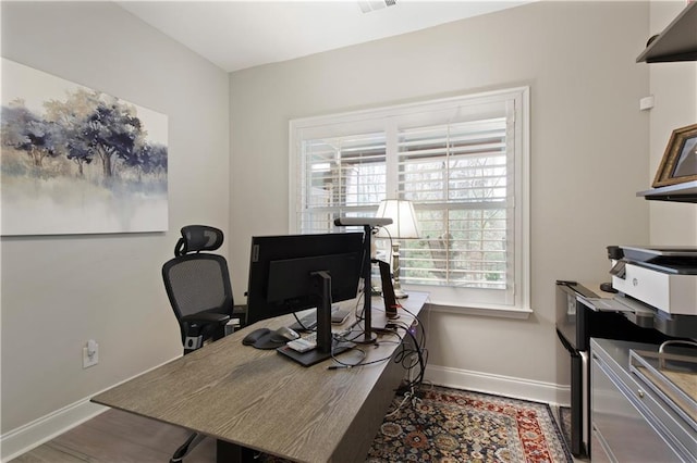 office space with wood finished floors, visible vents, and baseboards