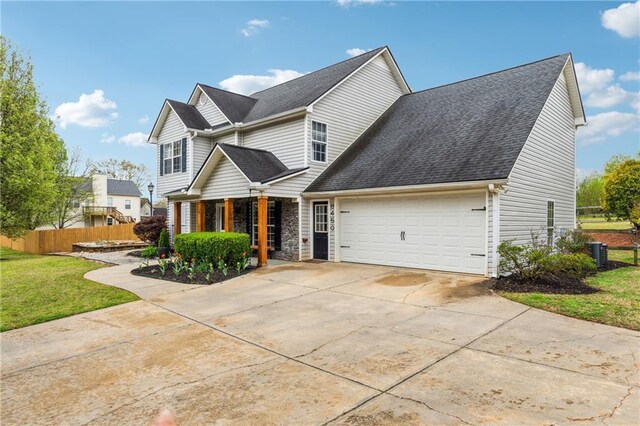 8450 Jot Em Down Rd, Gainesville, GA 30506 - view of front facade featuring a garage, fence, central AC unit, a front yard, and driveway
