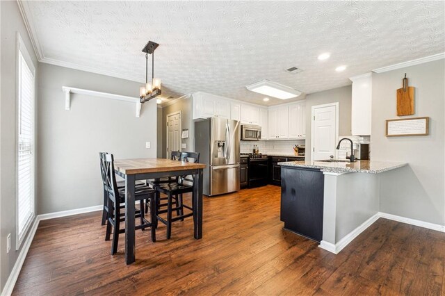 8450 Jot Em Down Rd, Gainesville, GA 30506 - kitchen with a sink, a peninsula, backsplash, stainless steel appliances, and white cabinets