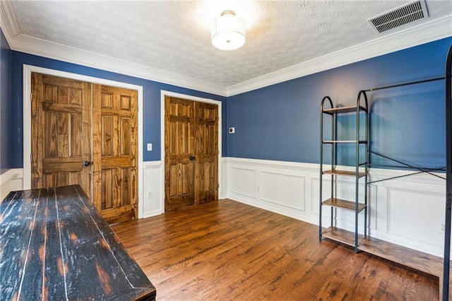 8450 Jot Em Down Rd, Gainesville, GA 30506 - entrance foyer featuring a textured ceiling, ornamental molding, wainscoting, visible vents, and wood finished floors