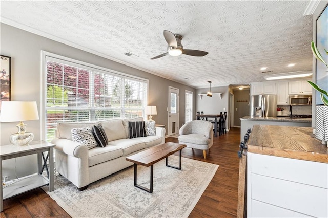 8450 Jot Em Down Rd, Gainesville, GA 30506 - living room with ceiling fan, crown molding, dark wood-type flooring, and visible vents