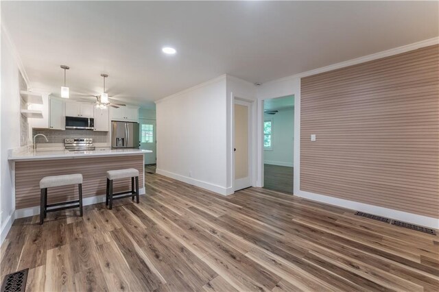 3620 W Lawrenceville St, Duluth, GA 30096 - kitchen featuring appliances with stainless steel finishes, ornamental molding, white cabinetry, open shelves, and a peninsula