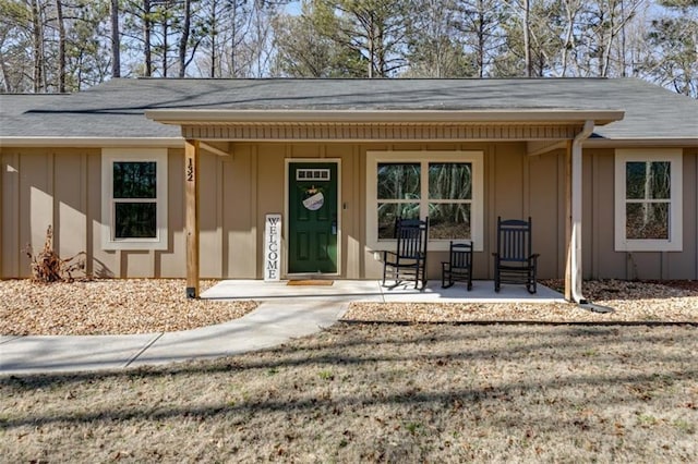 entrance to property featuring a lawn and covered porch