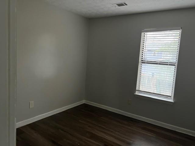 unfurnished living room featuring hardwood / wood-style flooring, a fireplace, and a textured ceiling