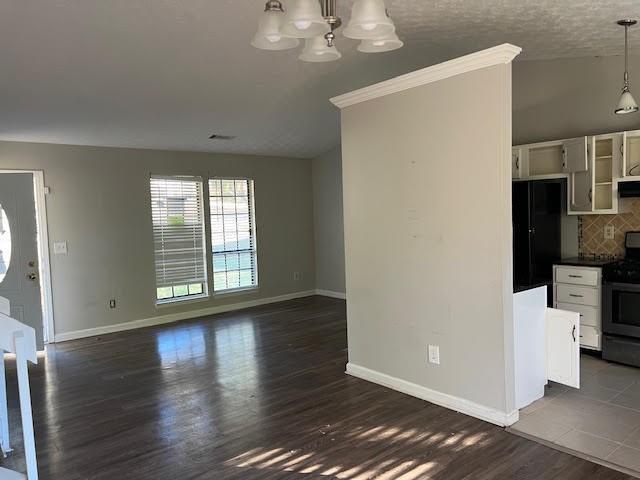 unfurnished living room with dark hardwood / wood-style flooring and a chandelier