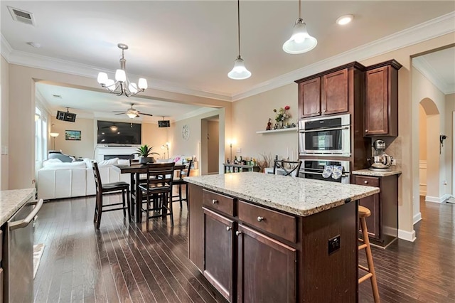 4708 Tiger Blvd, Duluth, GA 30096 - kitchen with arched walkways, dark wood-style floors, crown molding, appliances with stainless steel finishes, and hanging light fixtures