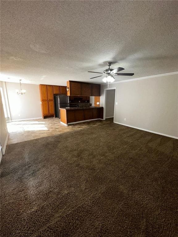 interior space with ceiling fan with notable chandelier, ornamental molding, carpet floors, and a textured ceiling