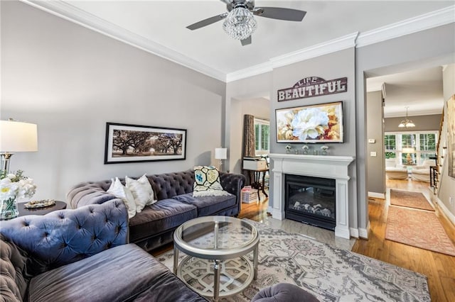 3150 Stonewyck Pl, Decatur, GA 30033 - living room with a ceiling fan, crown molding, wood finished floors, a glass covered fireplace, and baseboards