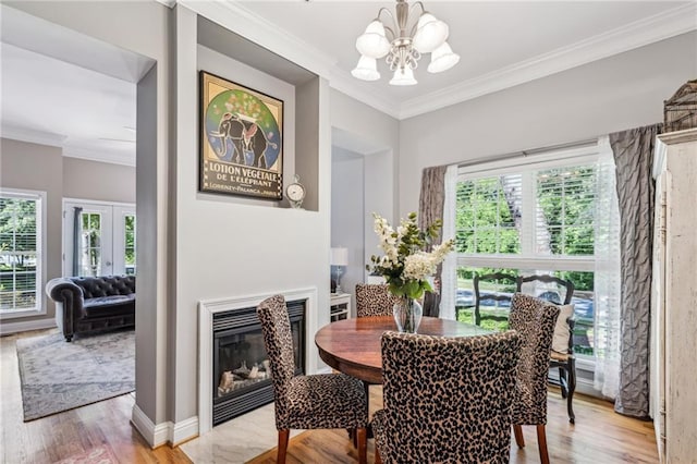 3150 Stonewyck Pl, Decatur, GA 30033 - dining space featuring a chandelier, ornamental molding, light wood-style floors, a glass covered fireplace, and baseboards