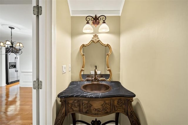 bathroom with ornamental molding, hardwood / wood-style floors, and vanity