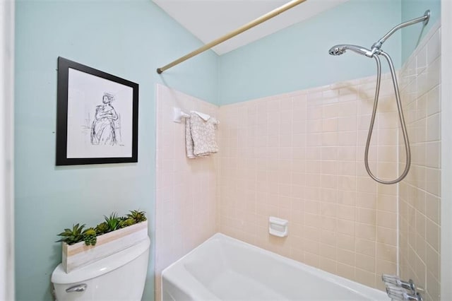 bathroom with tiled shower / bath combo and toilet