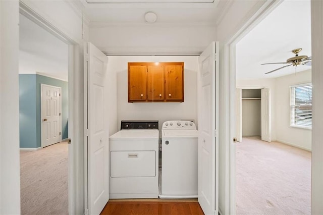 laundry room with ceiling fan, cabinets, washer and clothes dryer, and light carpet