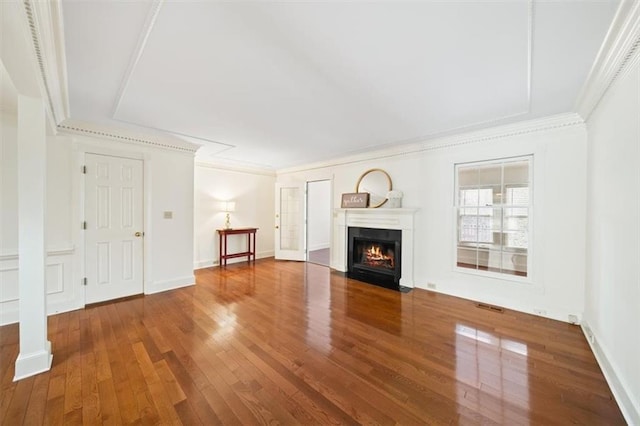 unfurnished living room with wood-type flooring and ornamental molding