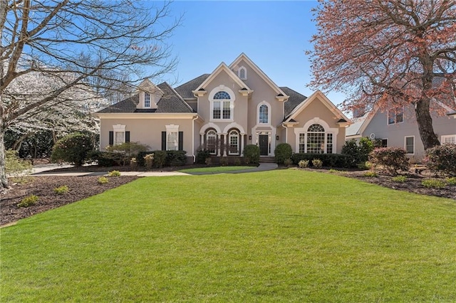 view of front of house featuring stucco siding and a front yard
