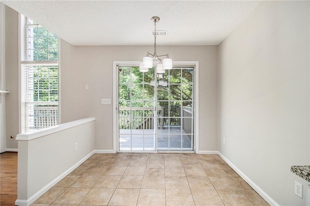 3710 Ridgefair Dr, Cumming, GA 30040 - unfurnished dining area with plenty of natural light, a textured ceiling, a chandelier, and light tile patterned flooring