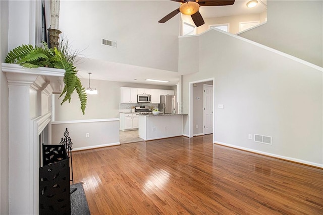 3710 Ridgefair Dr, Cumming, GA 30040 - unfurnished living room with ceiling fan, wood finished floors, and a towering ceiling