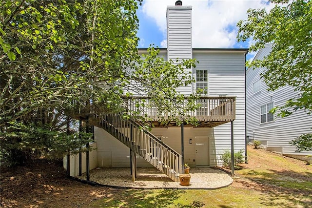 3710 Ridgefair Dr, Cumming, GA 30040 - back of house with a chimney, a wooden deck, and stairs