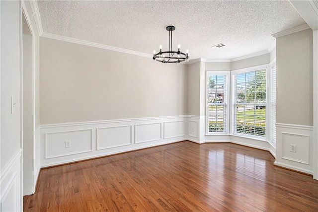3710 Ridgefair Dr, Cumming, GA 30040 - unfurnished room featuring a chandelier, wood finished floors, a wainscoted wall, a textured ceiling, and a decorative wall