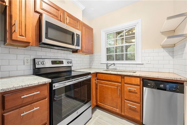 kitchen featuring stainless steel appliances, light stone countertops, sink, and backsplash